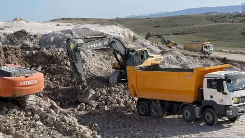 Alternatif Power’ın 8 MW biyogaz tesisi sahasında kaya hafriyatı yapan Volvo ve Hitachi ekskavatörlerle sarı damperli kamyonların görünümü.
