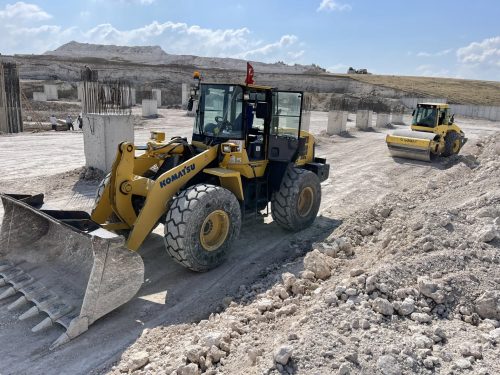 Pınar Mermer yeni fabrika dolgu sahasında Komatsu lastikli yükleyicimiz, arkasında Bomag zemin silindirimiz ve betonarme temel elemanları.