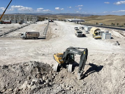 Pınar Mermer yeni fabrika sahasında prefabrik yapı, dolgu alanı, Volvo ekskavatörümüz, damperli kamyonlarımız ve zemin silindirimizin görünümü.
